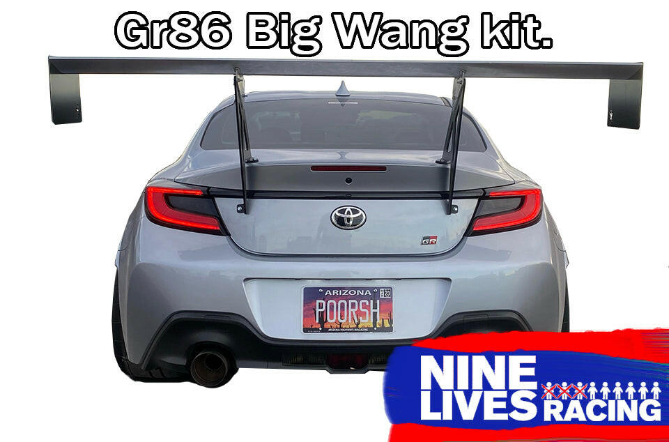 A grey Toyota GR86 with a large rear wing, viewed from the back. The license plate reads "POORSH." Text at the top reads "GR86 / BRZ Wang Kit '22+," featuring performance airfoils. The bottom right corner displays the 9livesracing logo.